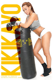 Kiki Kayo posing with a heavy bag and boxing gloves on