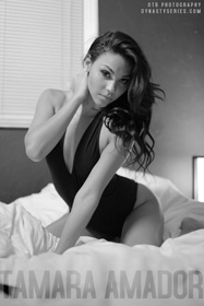 Tamara Amador posing on a bed in black lingerie